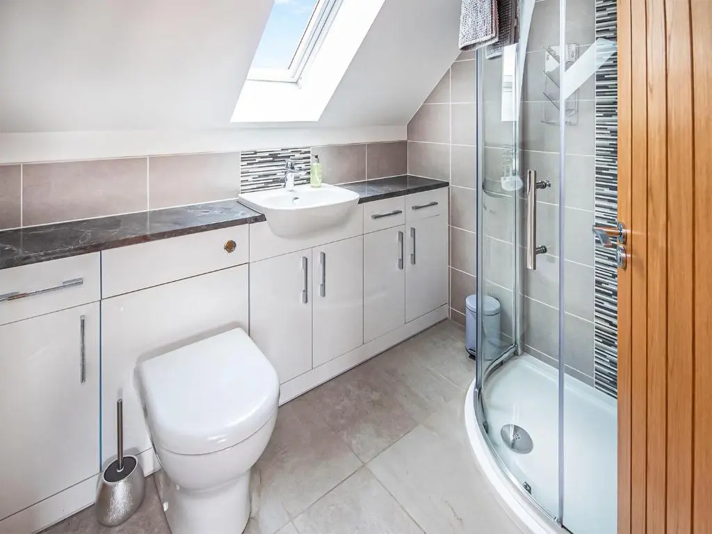 a bathroom with a toilet and a sink and a shower at Beinn View House in Cononbridge