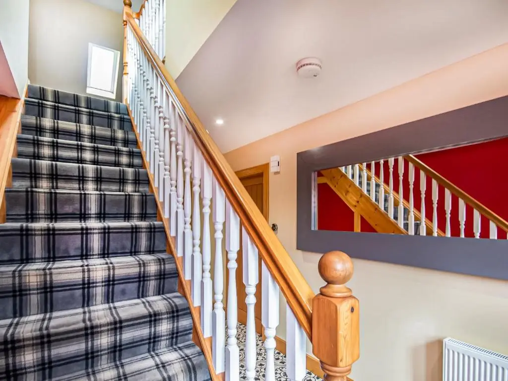 a staircase in a home with blue and white carpet at Beinn View House in Cononbridge