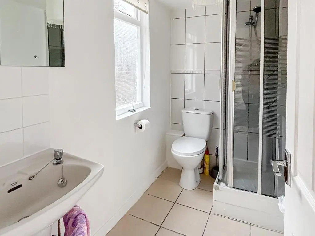 a white bathroom with a toilet and a sink at Ivydene Cottage in Cromarty