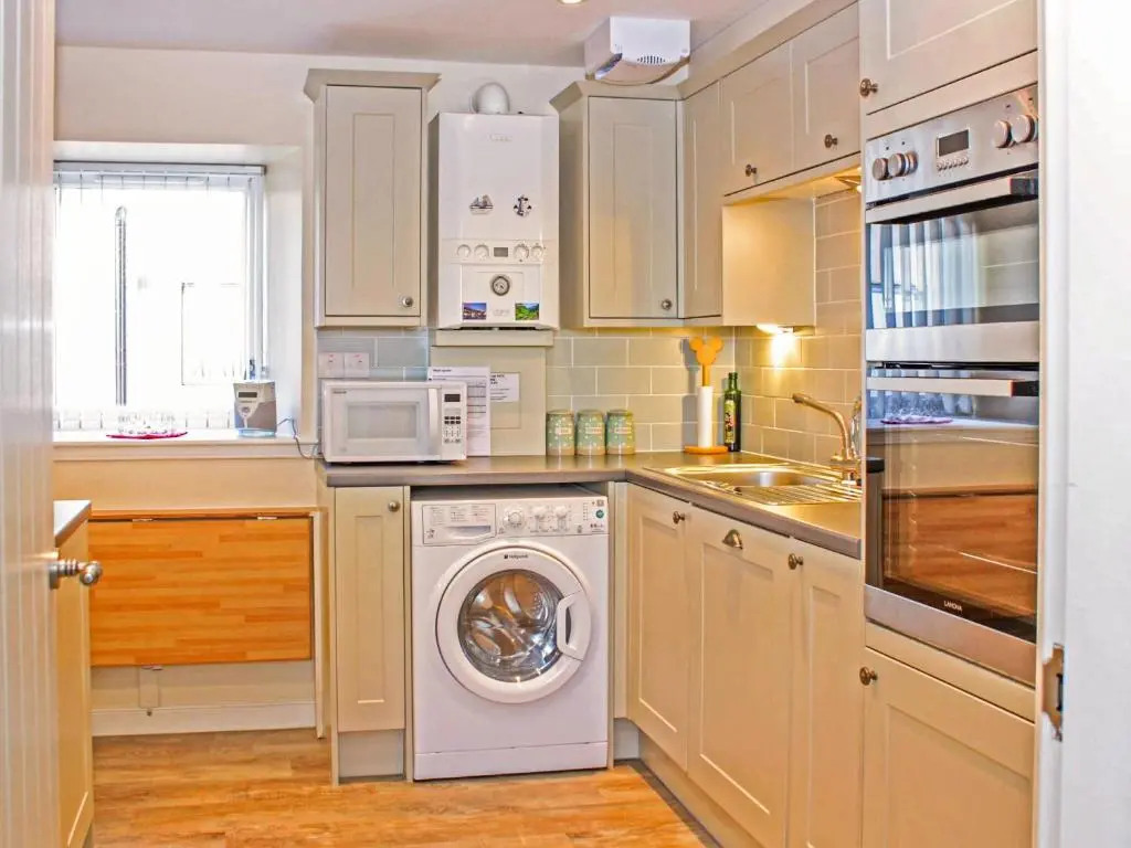 a kitchen with a washing machine and a microwave at Apartment 8 The Granary-Uk7466 in Banff