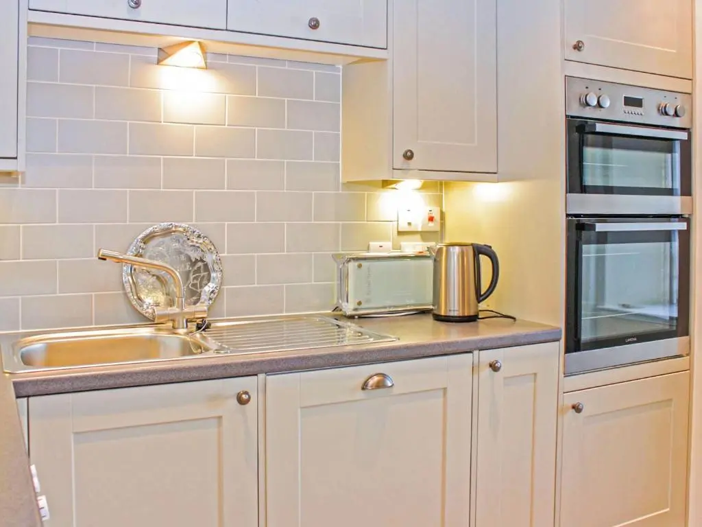 a kitchen with white cabinets and a sink at Apartment 8 The Granary-Uk7466 in Banff