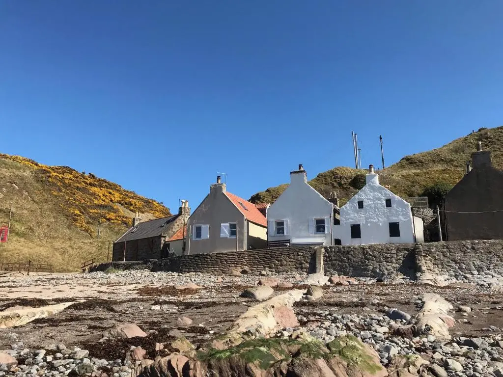 a group of houses on a rocky beach at Crovie Cottage in Gardenstown