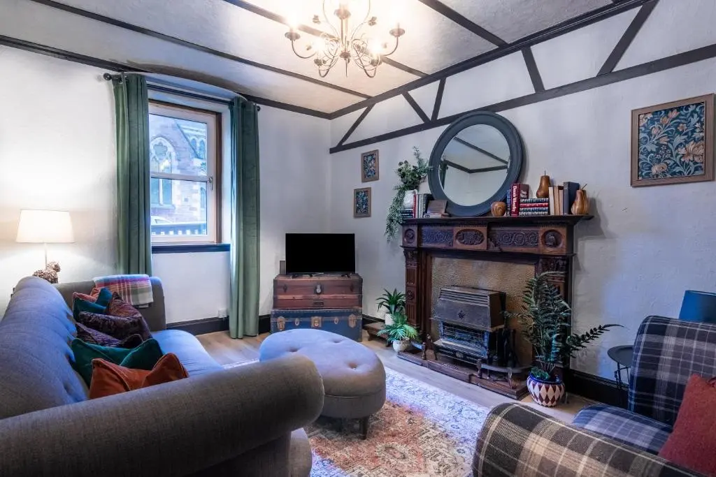 a living room with a couch and a mirror at Criss Cross Cottage in Inverness