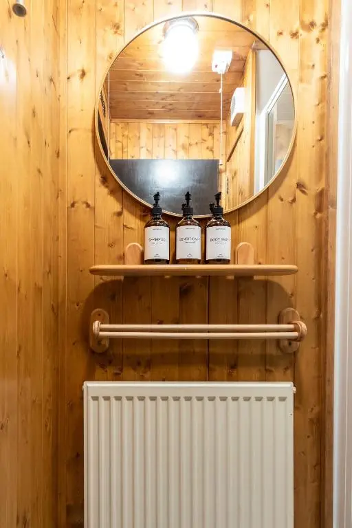 a bathroom with three bottles of soap on a shelf at Criss Cross Cottage in Inverness