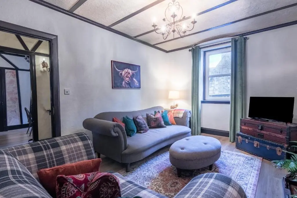 a living room with a couch and a tv at Criss Cross Cottage in Inverness
