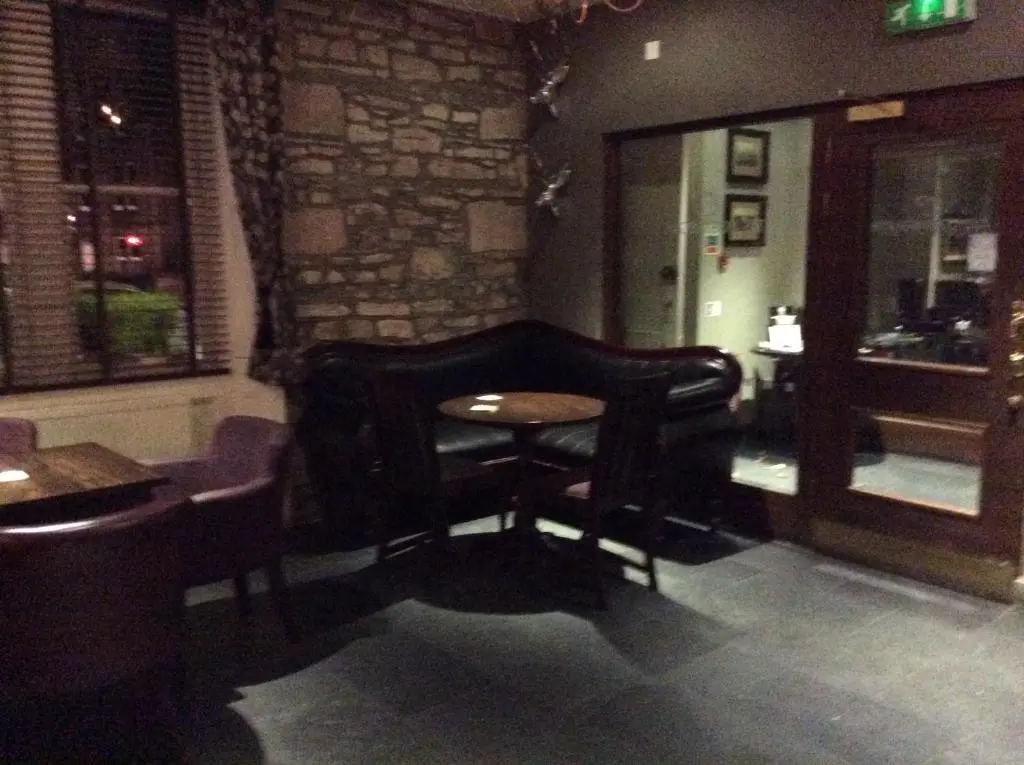 a bar with a chair and a table in a room at Corriegarth Hotel in Inverness
