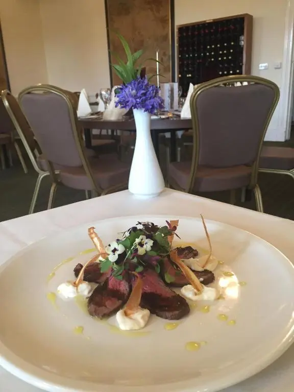 a plate of food on a table with a vase at Nethybridge Hotel in Nethy Bridge