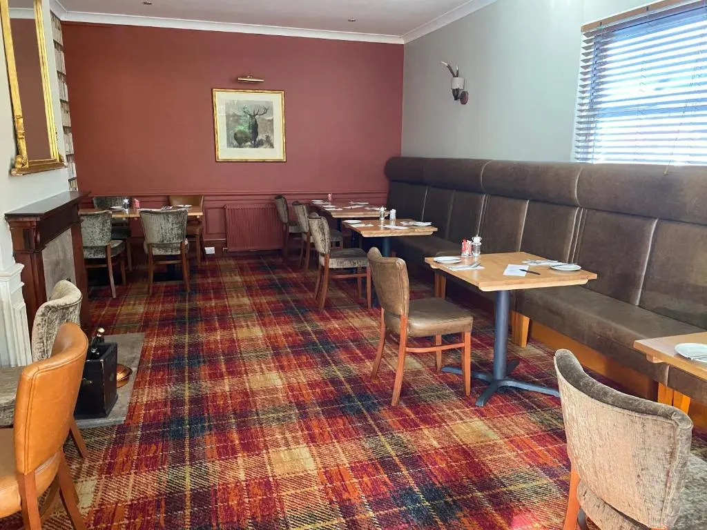 a dining room with tables and chairs and a couch at Boat Country Inn and Restaurant in Boat of Garten