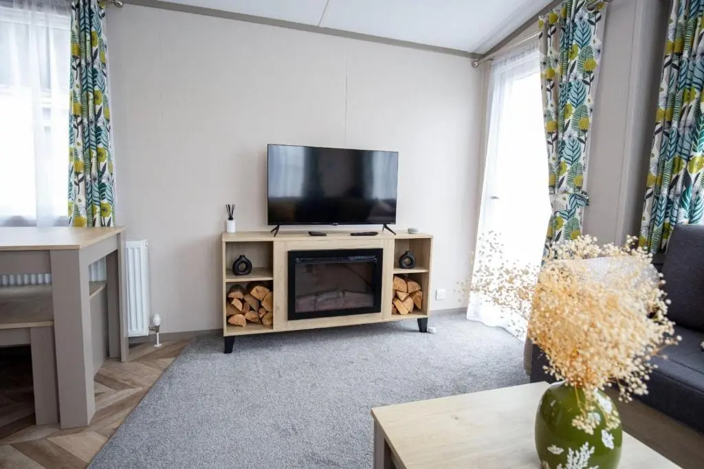 a living room with a flat screen tv on a stand at Grantown Get Away - SJA Stays - Modern 2 Bed Static in Grantown on Spey