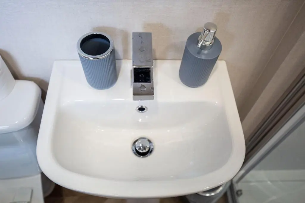 a white sink with two cups on top of it at Grantown Get Away - SJA Stays - Modern 2 Bed Static in Grantown on Spey