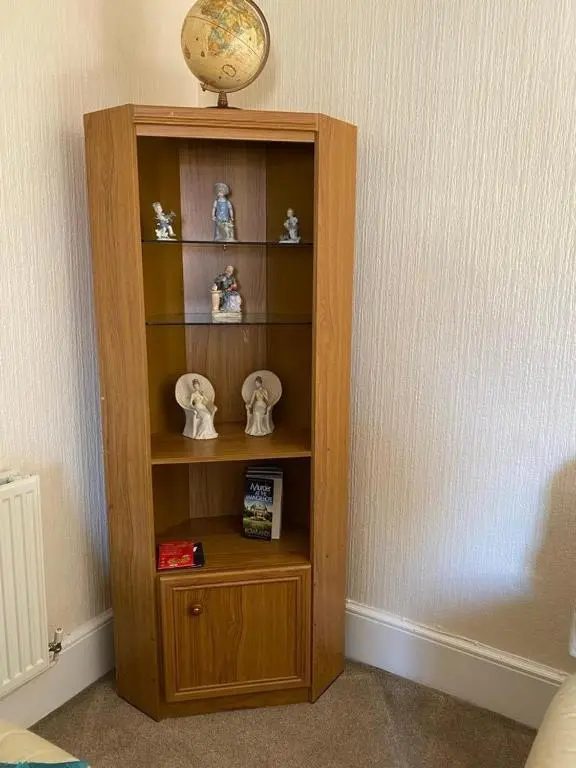 a wooden book shelf with a clock on top of it at 2 Bed Cottage Sleeps 4-Pets Welcome-Private Garden in Buckie