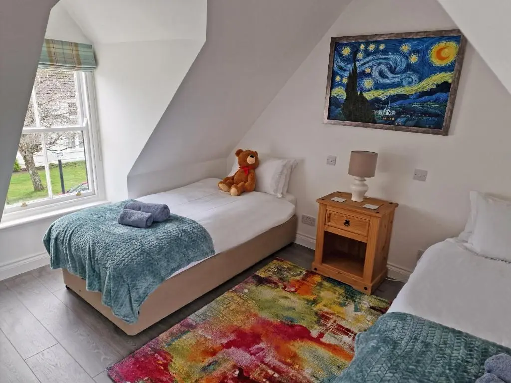 a teddy bear sitting on a bed in a bedroom at House - Sleeps 8 - Pets Ok - Parking in Ullapool