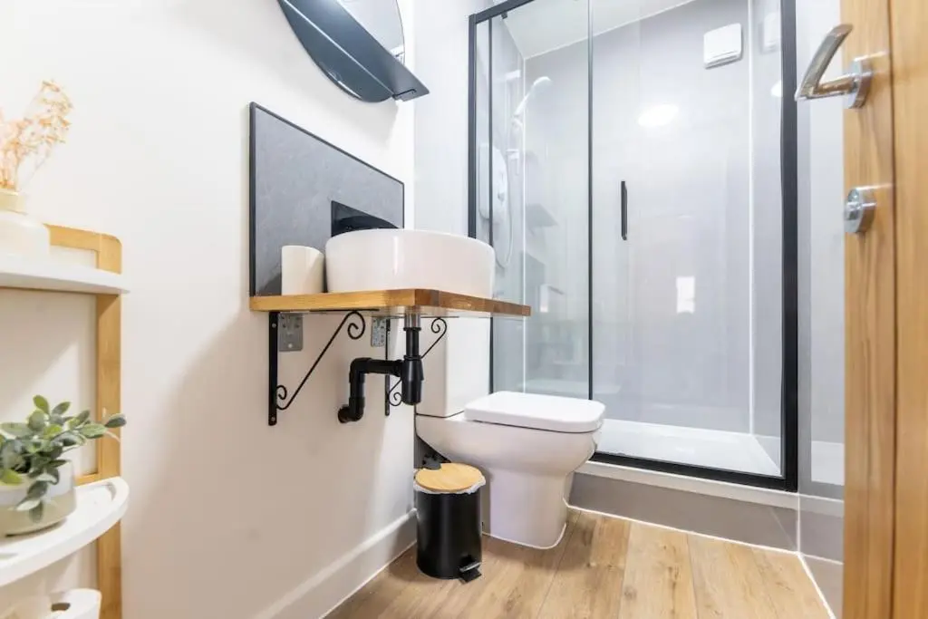 a bathroom with a toilet and a glass shower at Town centre flat in Inverness
