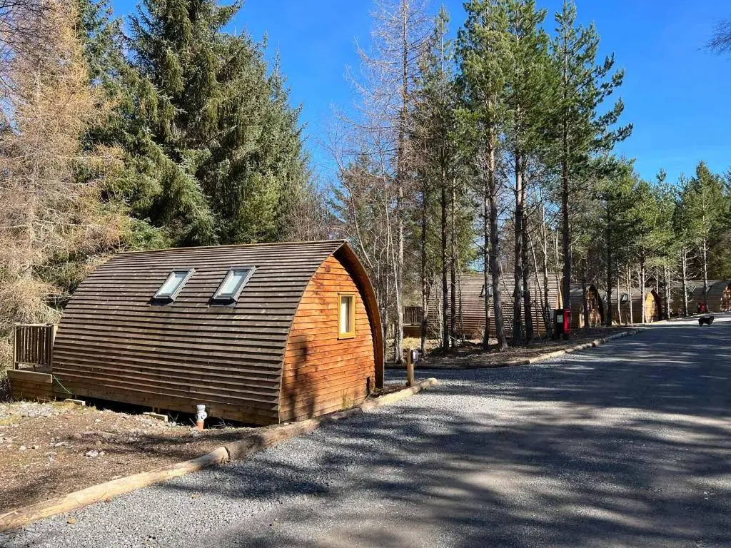 a wooden barn with two windows on the side of a road at Glenlivet by Wigwam Holidays in Tomintoul