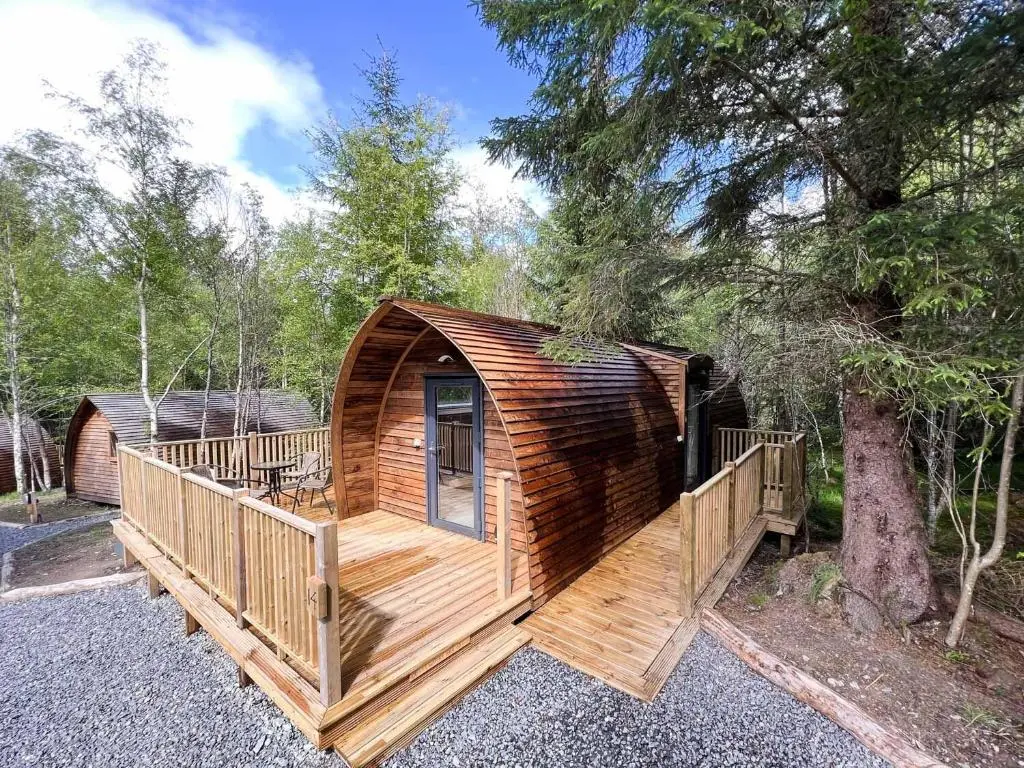 a large wooden cabin with a large deck at Glenlivet by Wigwam Holidays in Tomintoul
