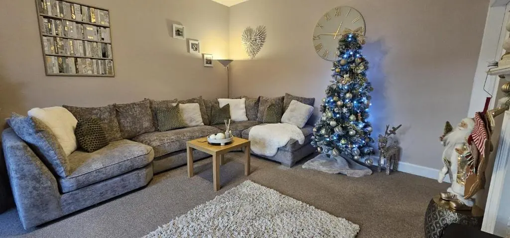 a living room with a couch and a christmas tree at Balmore Farmhouse near Lochness in Inverness