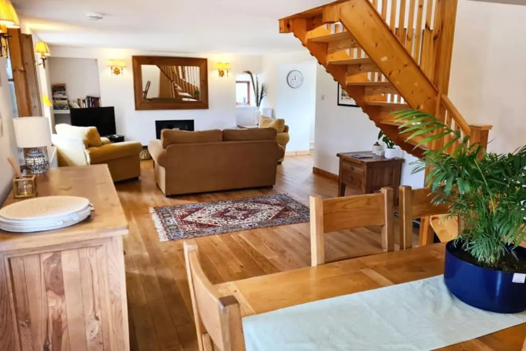 a living room with a couch and a staircase at Grieves Cottage, near Dornoch in Dornoch