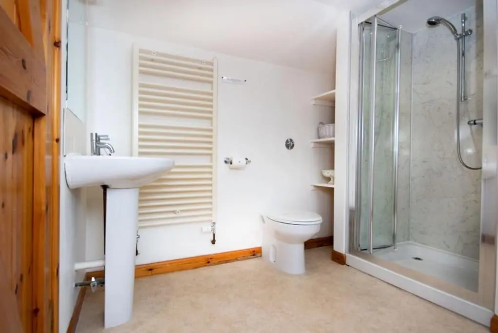 a bathroom with a toilet and a sink and a shower at Grieves Cottage, near Dornoch in Dornoch