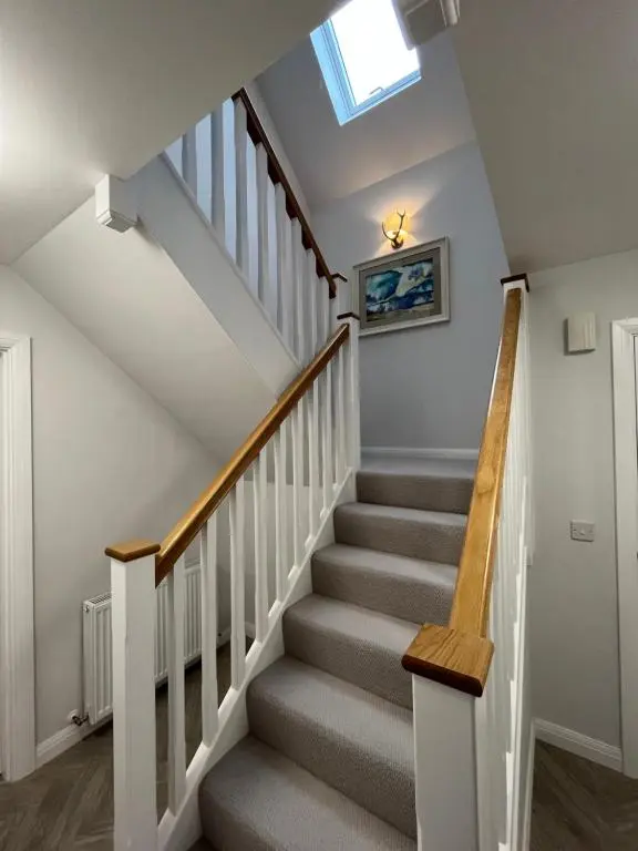 a staircase in a home with a skylight at The Beech House in Aviemore