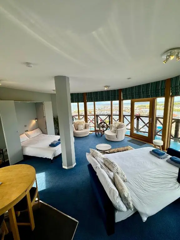 a hotel room with two beds and a table at The Lighthouse in Nairn