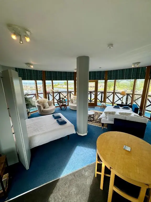 a large room with two beds and a table at The Lighthouse in Nairn