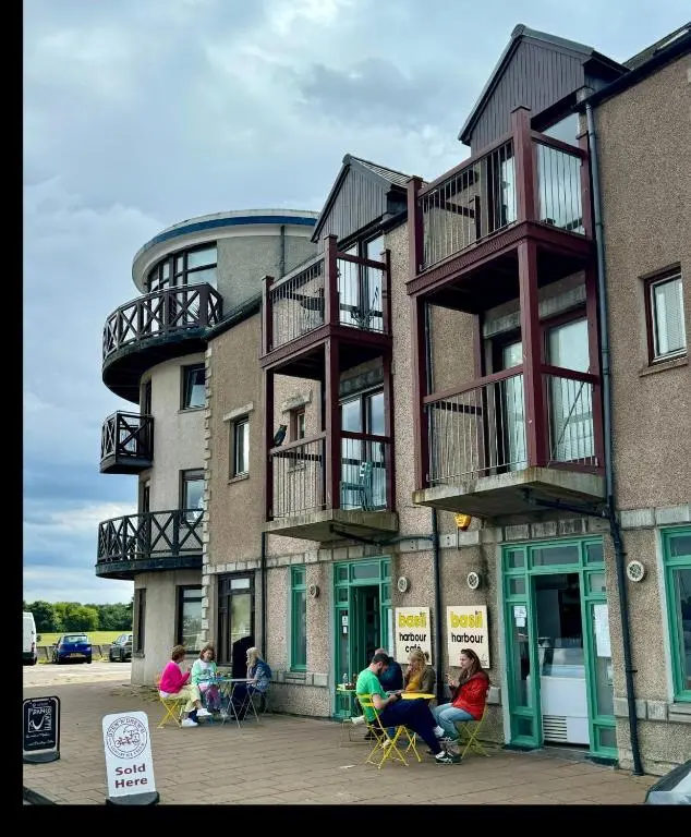a group of people sitting outside of a building at The Lighthouse in Nairn