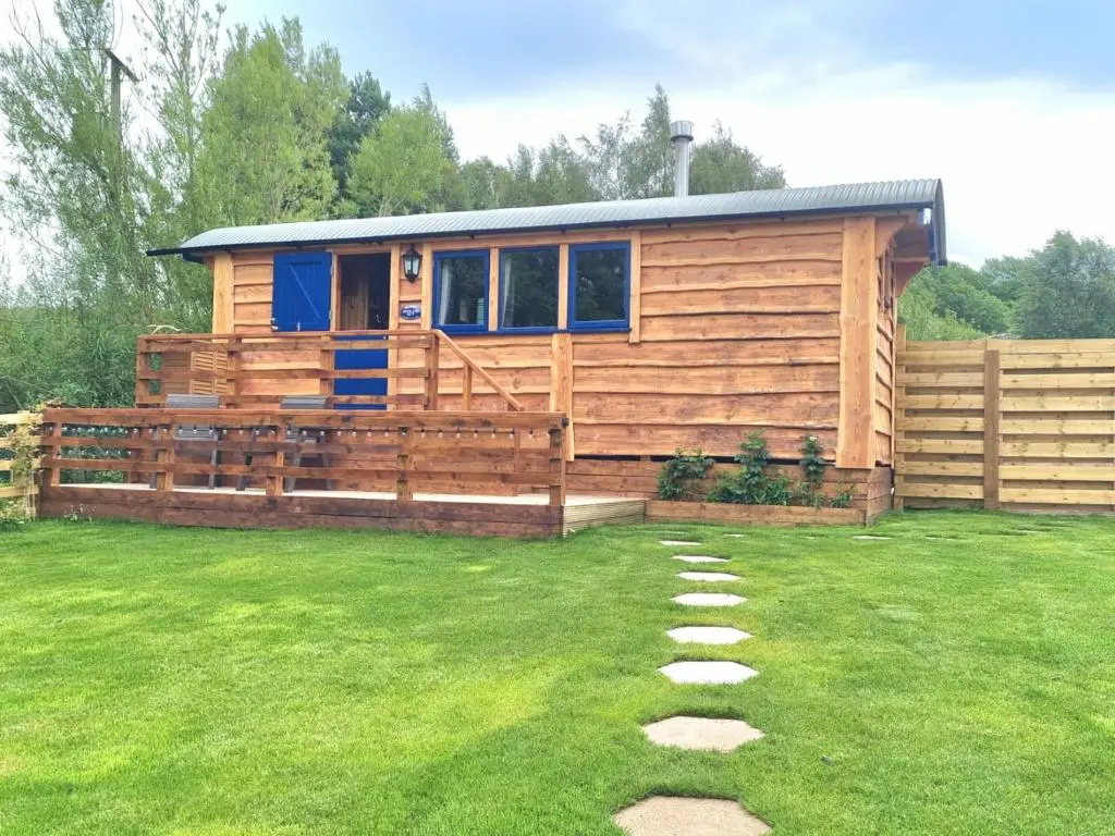 a wooden cabin in a yard with a fence at The Shepherds Neuk in Inverness