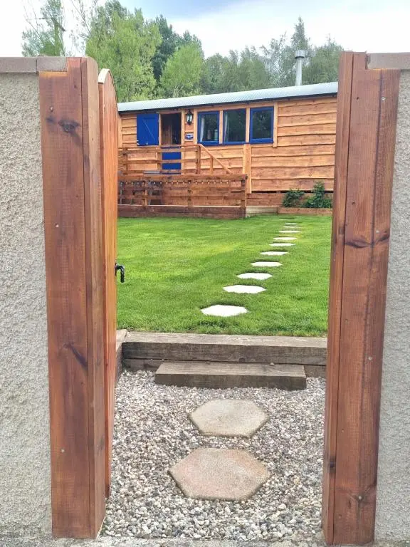 an open door to a house with a yard at The Shepherds Neuk in Inverness