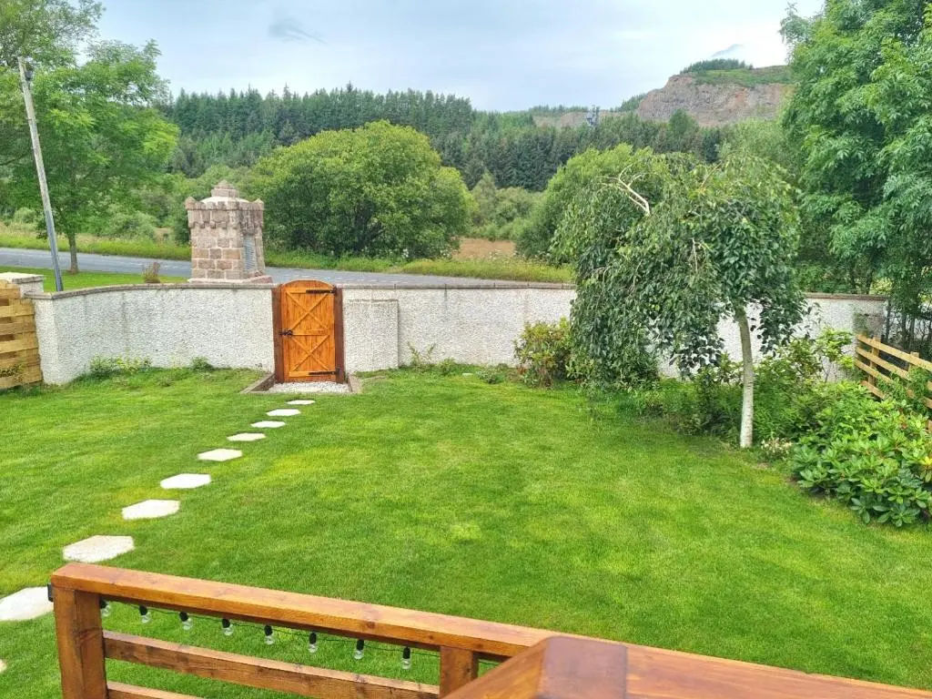 a garden with a bench in the grass at The Shepherds Neuk in Inverness