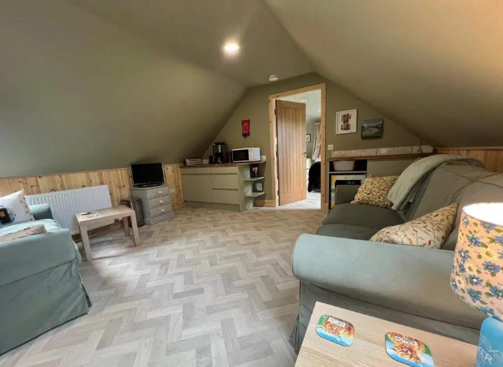 a living room with a couch and a table at Endeavour Guest House in Aberdeen