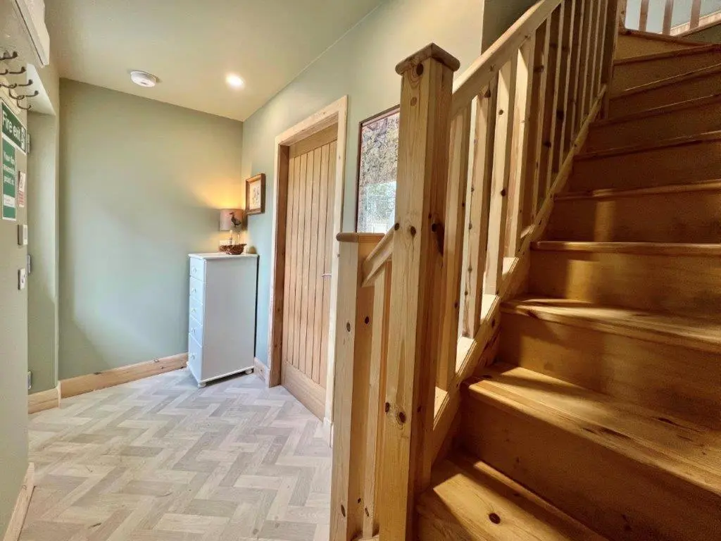 a hallway with wooden stairs in a home at Endeavour Guest House in Aberdeen