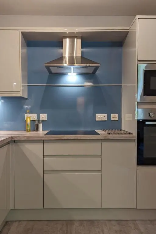 a kitchen with white cabinets and a stove top oven at The Wee Heilan' Coo in Nairn
