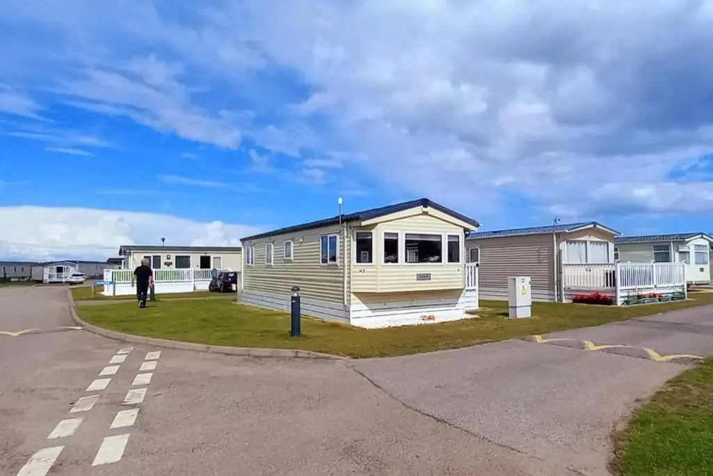 a man standing in front of a mobile home at Coral Cove in Lossiemouth