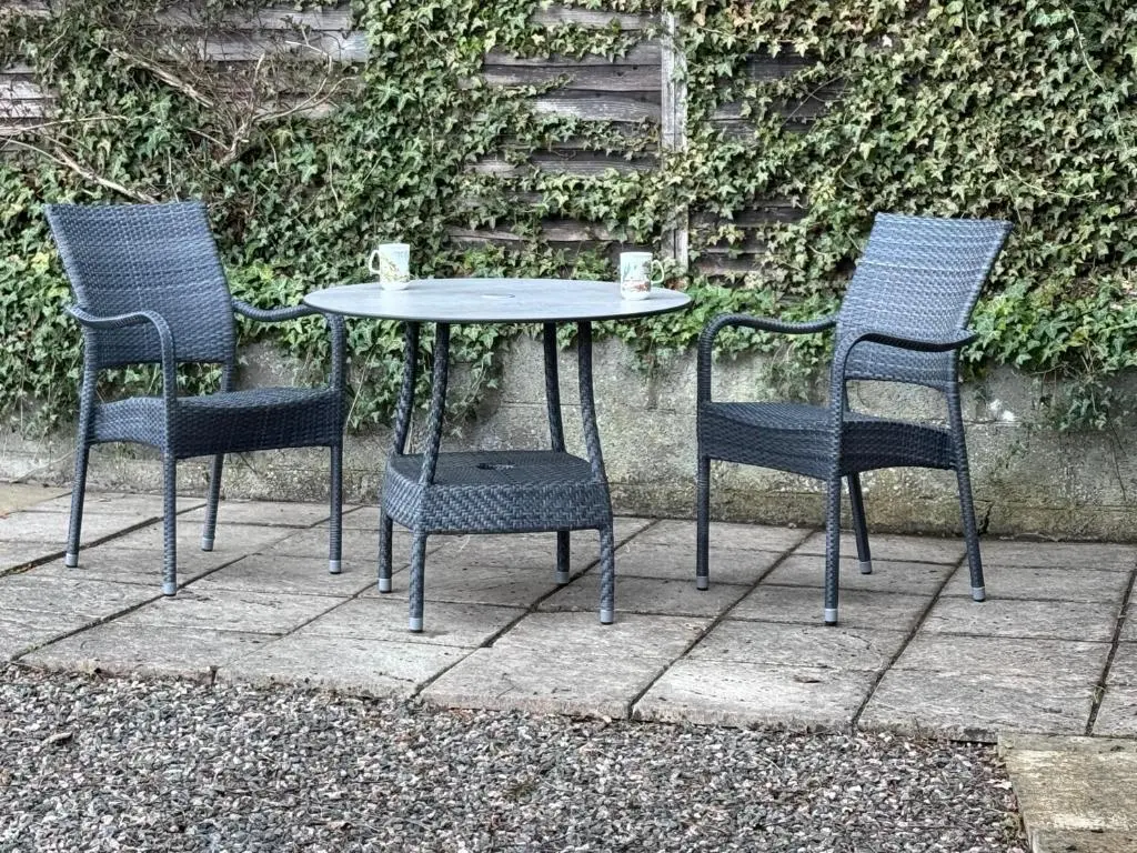 a table with three chairs and a table with two cups at Oaklyn,Highland Village of Beauly, Quiet Neighbourhood, One Bed, Min 5 nights in Beauly