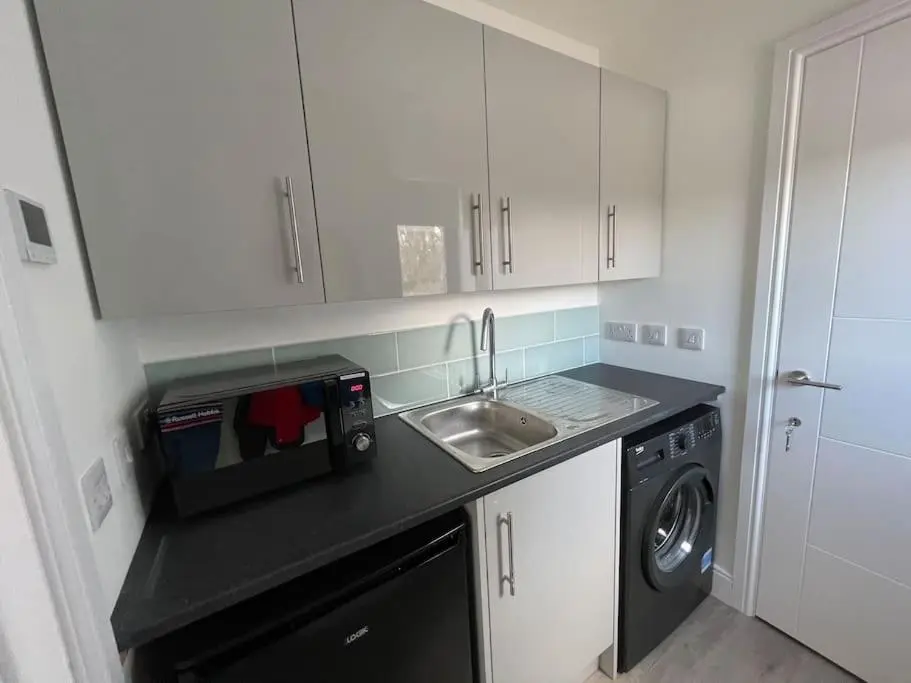 a small kitchen with a sink and a microwave at Ash Mill - Dornoch in Dornoch