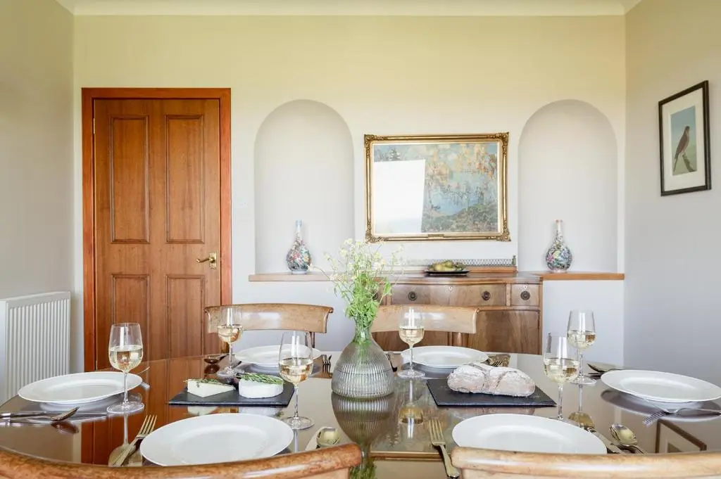 a dining room with a glass table and chairs at Fairways - Seasgair Lodges in Nairn