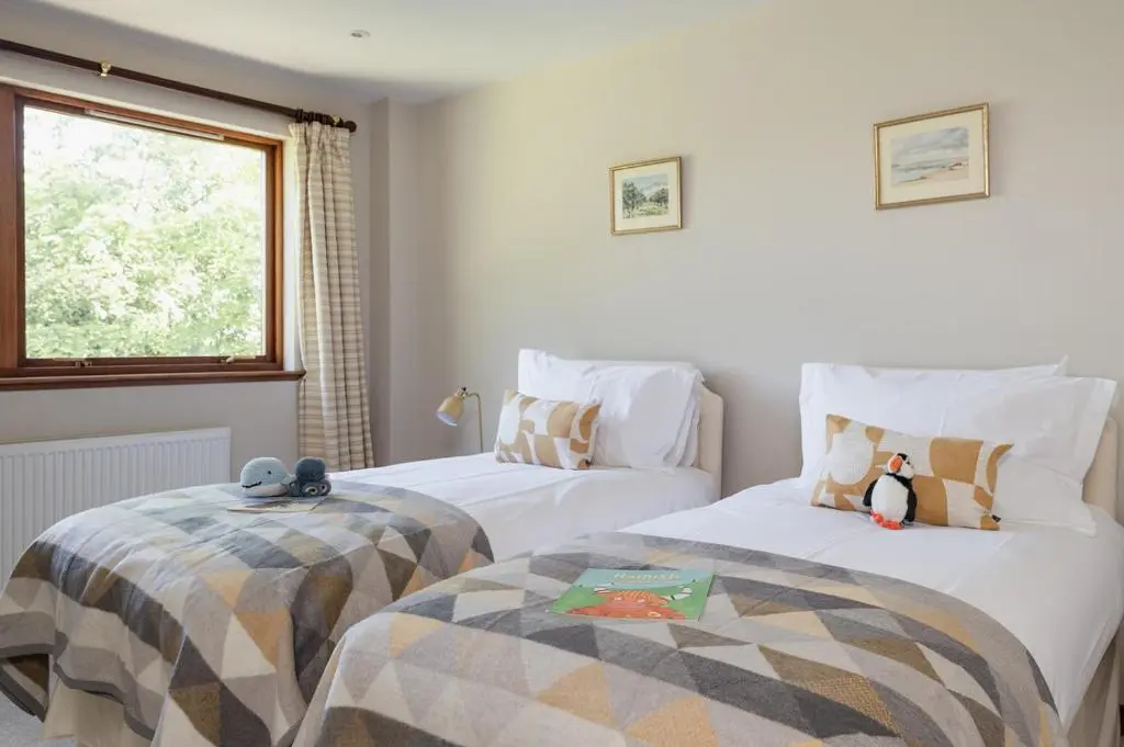 two beds with stuffed penguins on them in a room at Fairways - Seasgair Lodges in Nairn