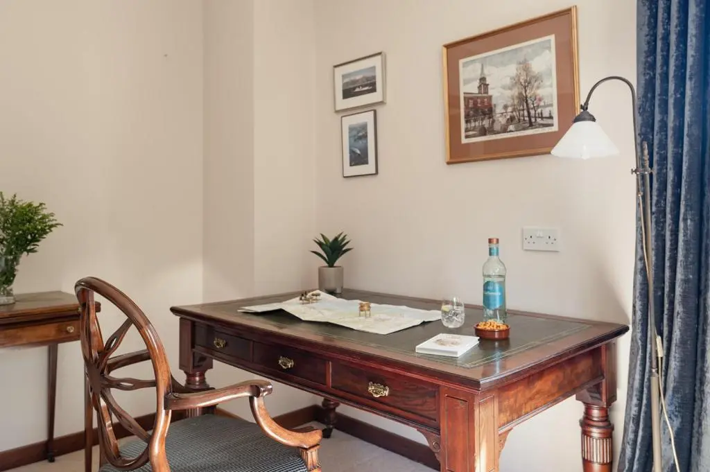 an old wooden desk with a chair and a lamp at Fairways - Seasgair Lodges in Nairn