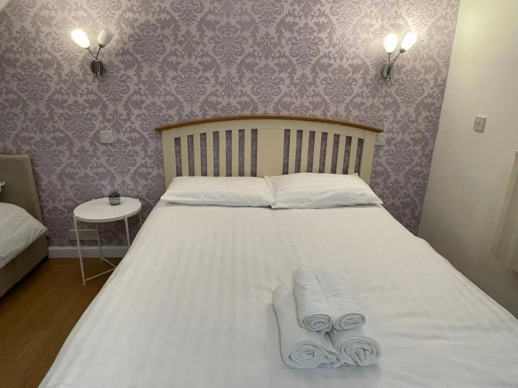 a bedroom with a bed with two towels on it at Sunshine three bedrooms Apartment in Insch