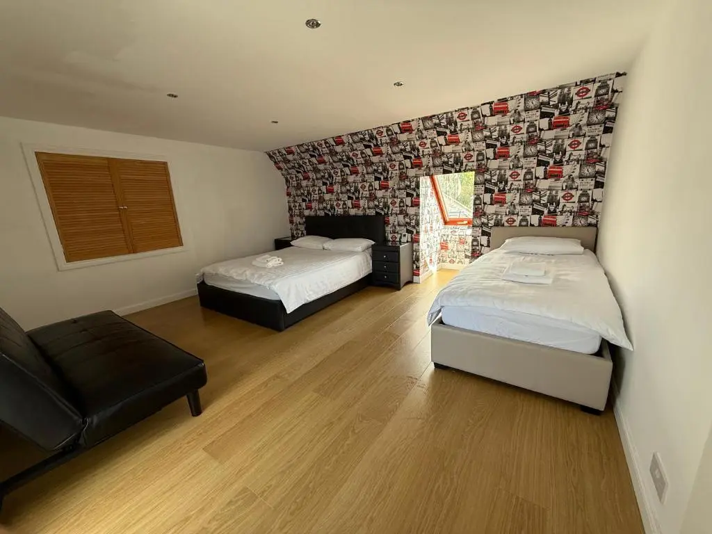 a bedroom with two beds and a couch in it at Sunshine three bedrooms Apartment in Insch