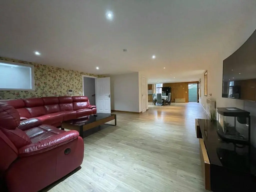 a living room with a red couch and a television at Sunshine three bedrooms Apartment in Insch
