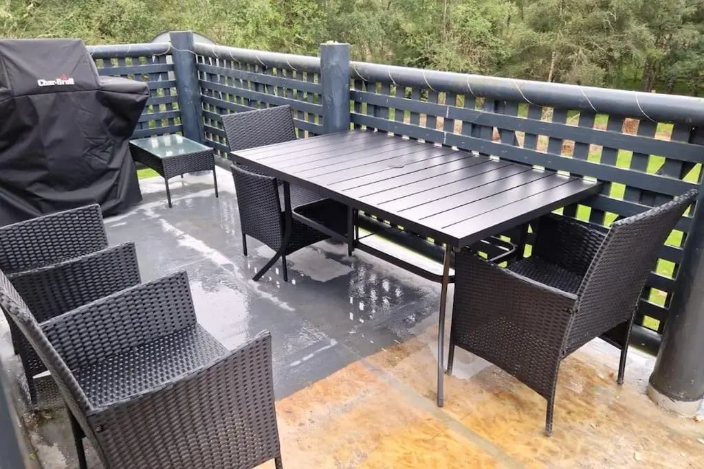 a wooden table and chairs on a patio at Heath House Loch Ness in Errogie