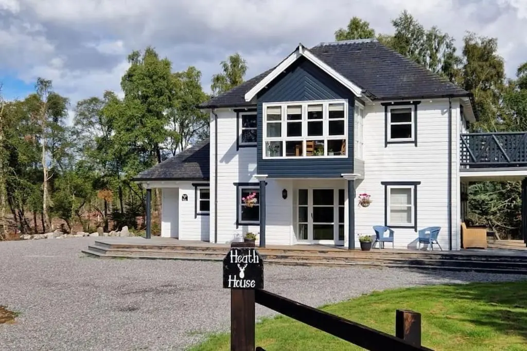 a white house with a sign in front of it at Heath House Loch Ness in Errogie