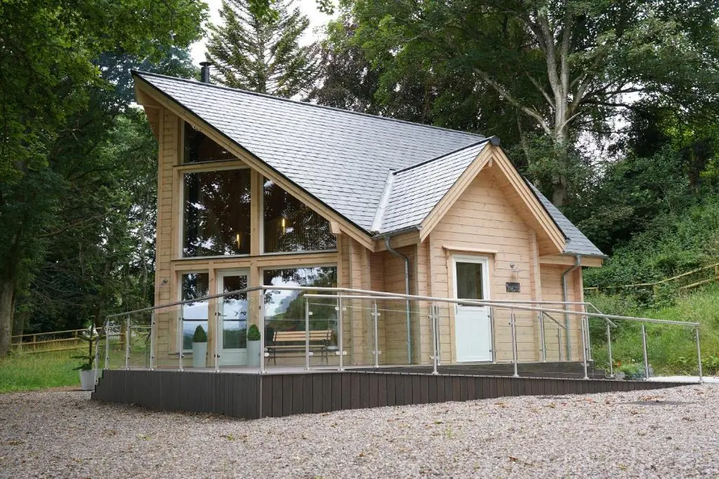 a small house with a large window and a roof at Cherry Tree Lodge in Inverness