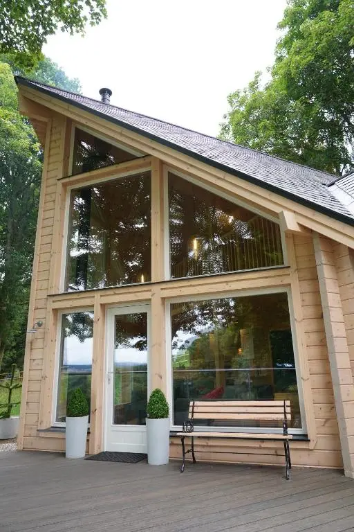 a screened in porch with a bench on a deck at Cherry Tree Lodge in Inverness