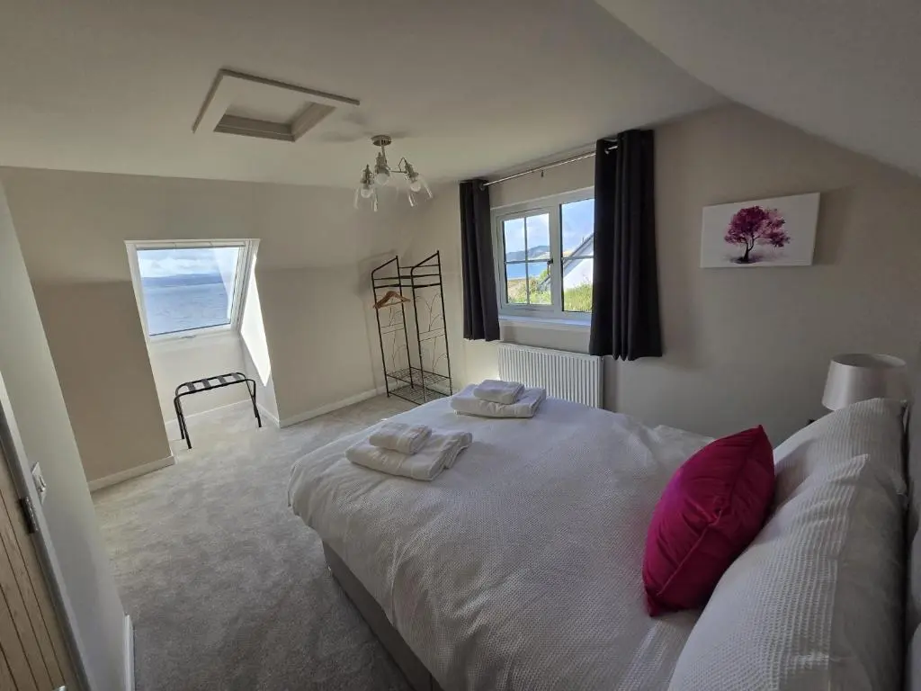 a bedroom with a large bed with two towels on it at Linden Cottage in Fortrose