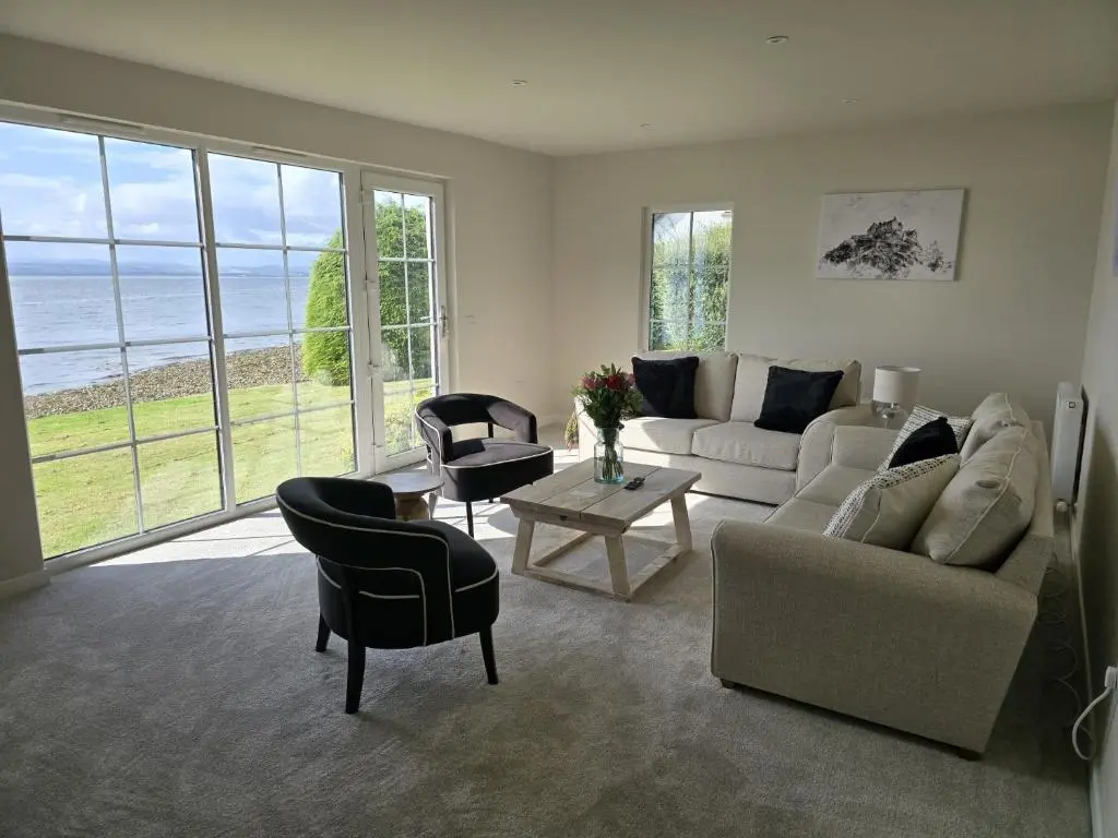 a living room with a couch and a table at Linden Cottage in Fortrose