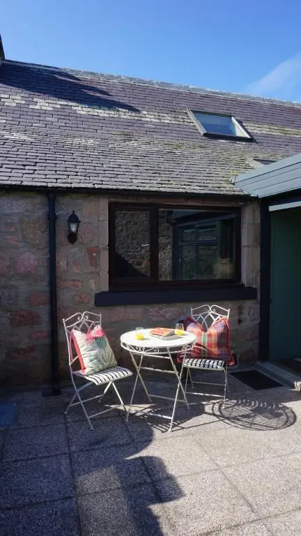 a table and two chairs in front of a house at Lewis Lodge - Stunning & Exclusive Luxury Home in the Heart of Ballater, Royal Deeside in Ballater