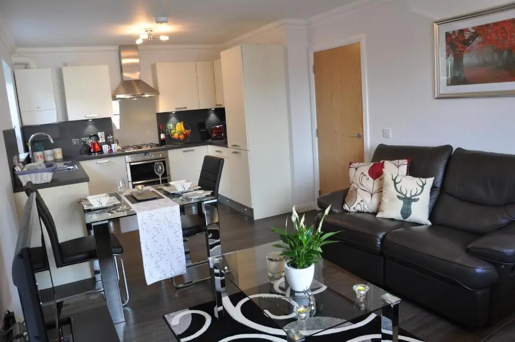a living room with a couch and a kitchen at Westgate Apartments Birchlee in Inverurie