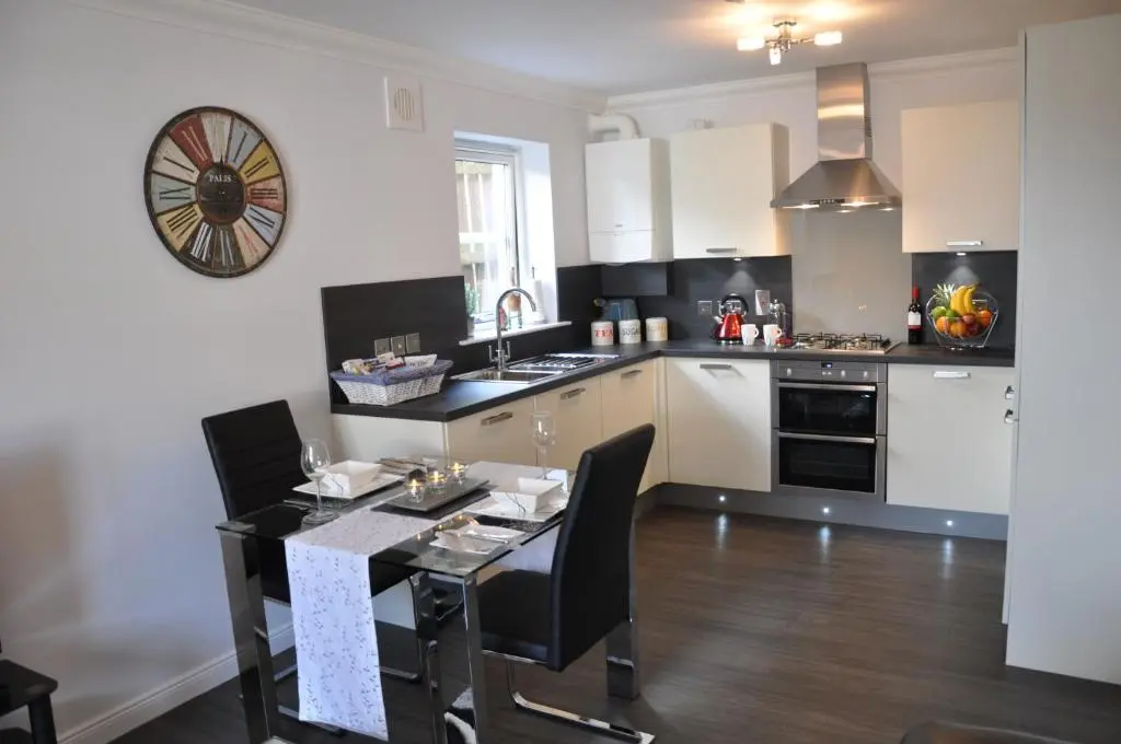 a kitchen with a table with chairs and a sink at Westgate Apartments Birchlee in Inverurie